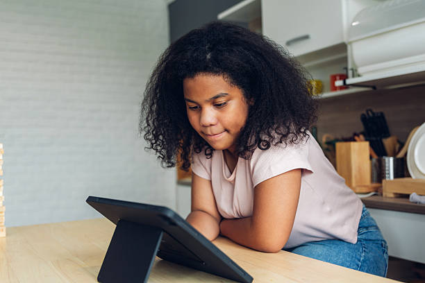 istock E-Learning. Happy Black Woman Student Using Tablet Computer at home. young African American girl using digital tablet at home. work from home 2218604982