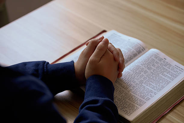istock “Hands clasped in prayer over a Holy Bible on a laptop, symbolizing faith and devotion in a digital age.” 2218605280