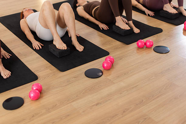 istock Women in barre and pilates class using props for lower body activation 2218608117