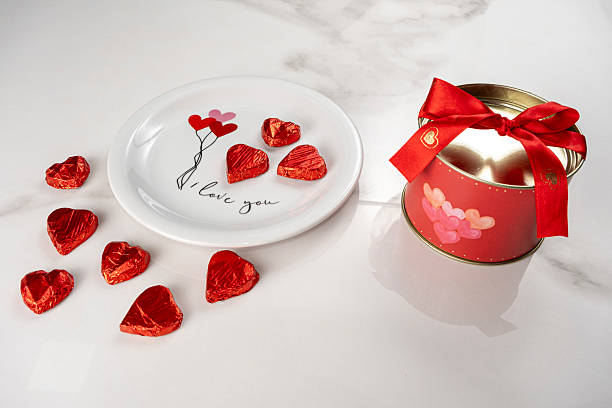 istock Heart shaped chocolates on a plate next to a red circular box. 2218608350