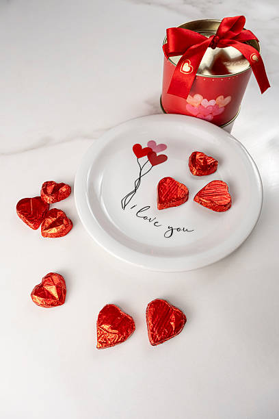 istock Heart shaped chocolates on a plate next to a red circular box_vertical. 2218608353