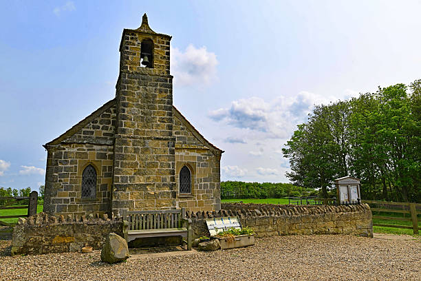 Old ruins of an abandoned stone church steeple, bell tower next to a beautiful cemetery. This color photography was taken during a sunny summer day, in end of july, in Isere department in middle of meadows between the villages of Bourcieu and Leyrieu in Auvergne-Rhone-Alpes region in France, Europe.