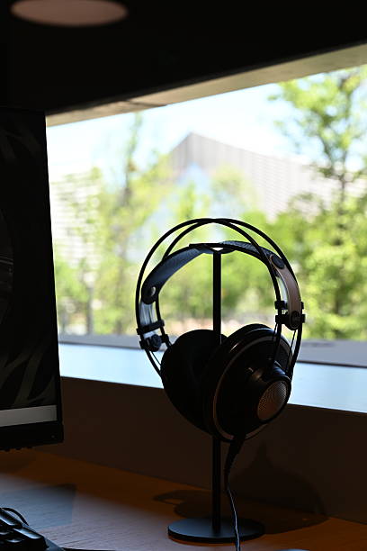 istock A sleek black headphone hangs neatly on a library media rack, its padded ear cups and adjustable headband ready for the next listener in this quiet reading space. 2218610359