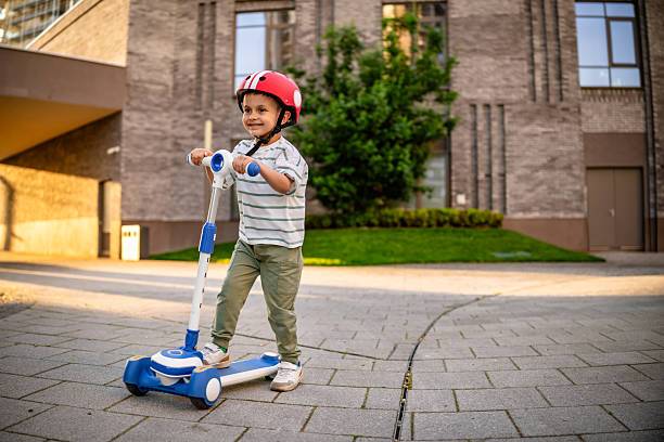 istock Child Riding Scooter Through the Street 2218610510