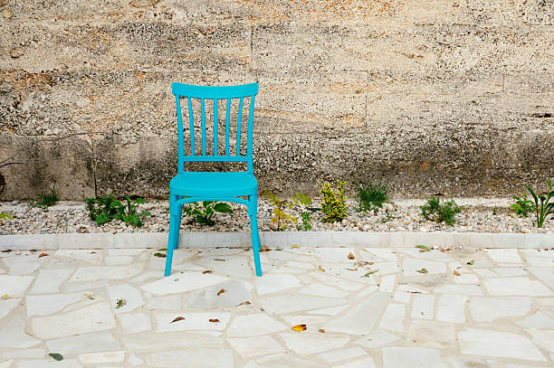 Vintage armchair with blue upholstery and wooden carvings. Close-up.