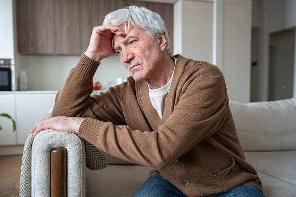 istock Lost sad elderly man with Alzheimer dementia sitting slumped on sofa, silent despair frustration 2218614375