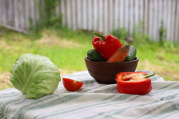 fresh vegetables such as cabbage tomatoes cucumbers peppers on a table in the village.