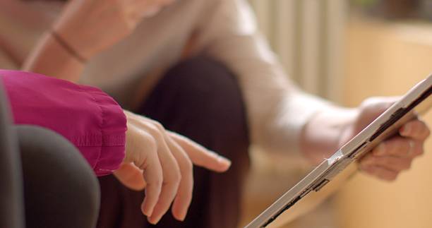 istock Two Individuals Engaging with a Tablet Device in a Relaxed Environment 2218618100