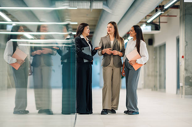 istock Businesswomen talking and collaborating in modern office hallway 2218621487