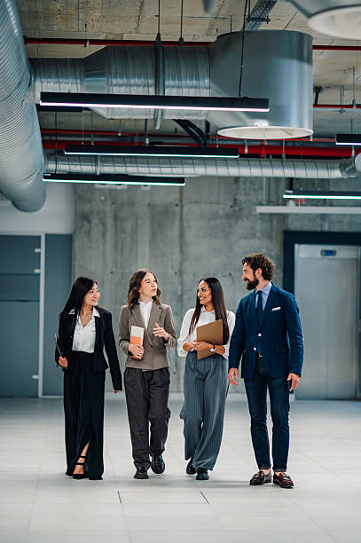 istock Businesspeople walking and talking in modern office building 2218621617