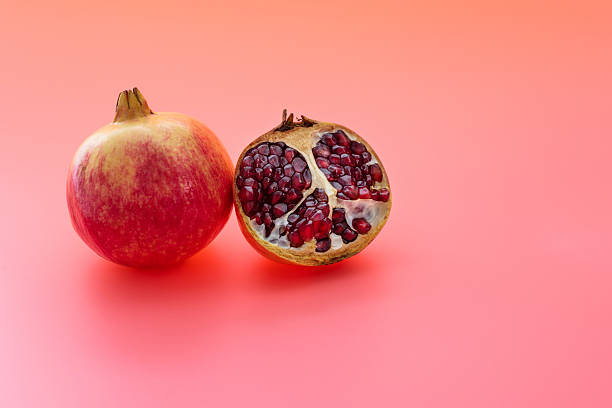 istock One and a half pomegranates on red background 2218622318
