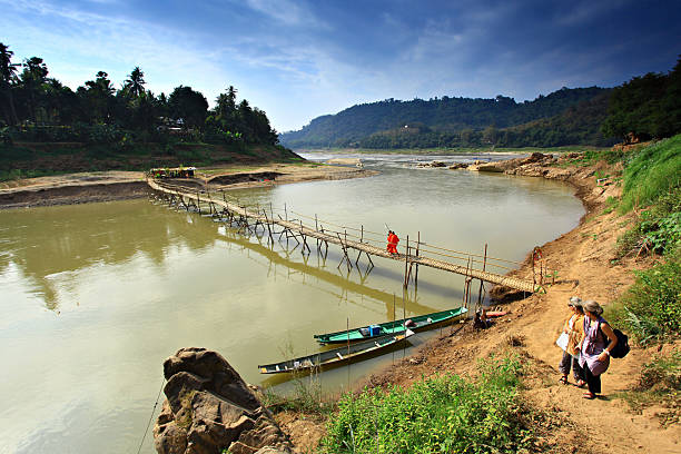 Luang Prabang, Laos - 30 December 2012: A medium-sized bamboo bridge serves as a shortcut for walking across the Khan River to enter Luang Prabang