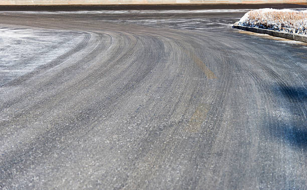 istock Car tire tracks on the snow road 2218623599