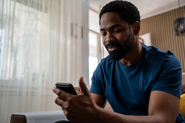 istock Man relaxing on the sofa using his smartphone 2218626218