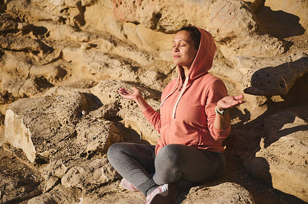 istock Woman Meditating Outdoors in Yoga Pose Practicing Mindfulness Under Warm Sun 2218629485