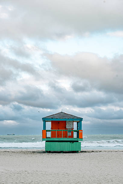 A yellow wooden lifeguard hut on an empty morning beach