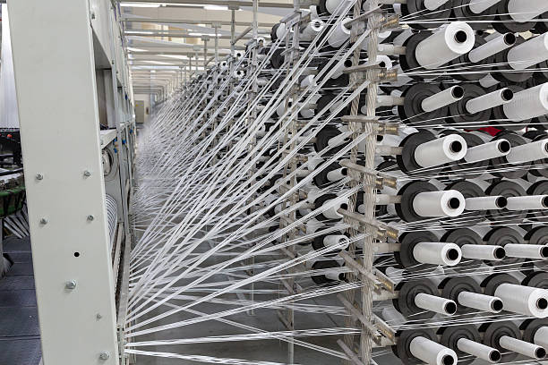 istock Factory equipment in perspective. Rows with coils of polypropylene threads for weaving cloth. Automatic machine. Nobody. 2218630675