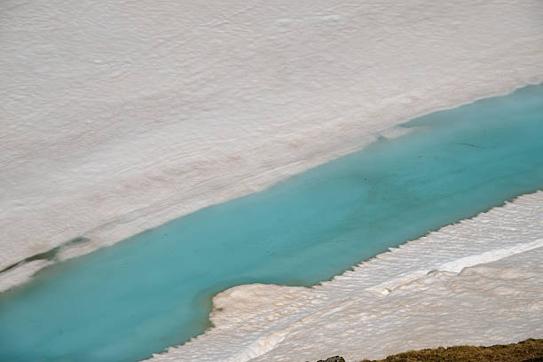 Aerial view of snow melting at Lac de l'Eychauda in the Écrins mountains of the French Alps