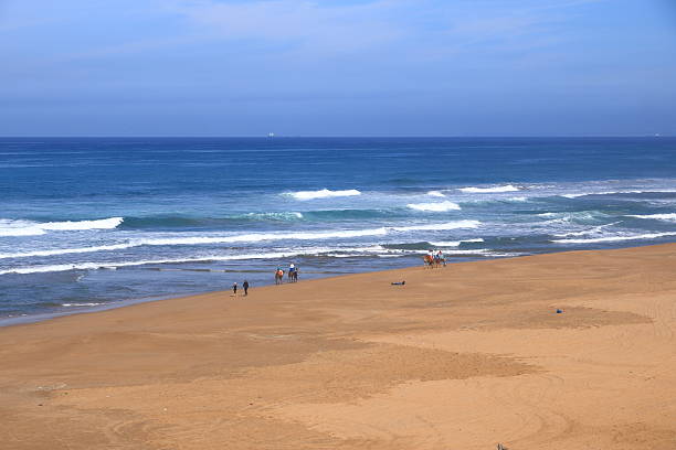 Tangier at Strait of Gibraltar, Morocco - February 17 2025: camel riding at the Atlantic Ocean