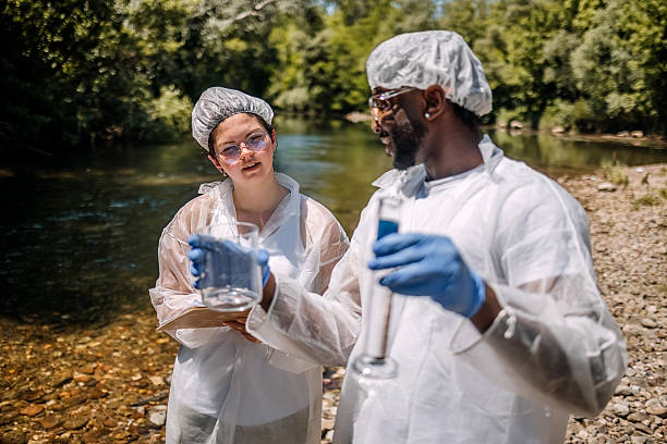istock Scientists checking for contamination together outdoors on field standing close to river 2218636378