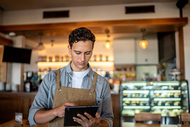 istock Young waiter using digital tablet at coffee shop 2218637687