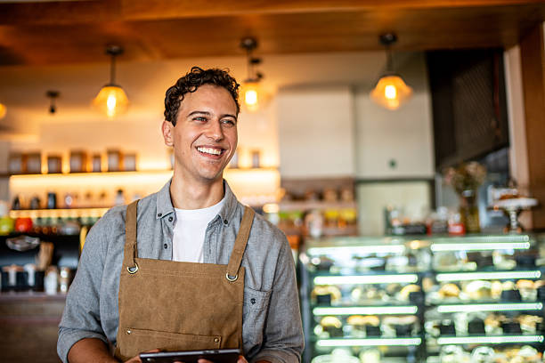 Young waiter contemplating at coffee shop