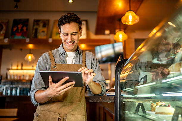 istock Young waiter using digital tablet at coffee shop 2218637702