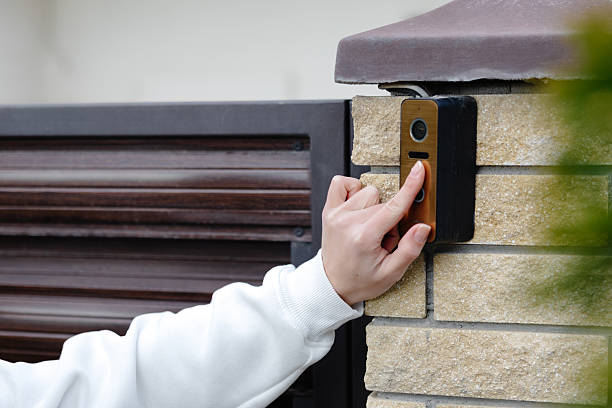 istock Woman pressing button on modern video intercom system at building entrance 2218638100