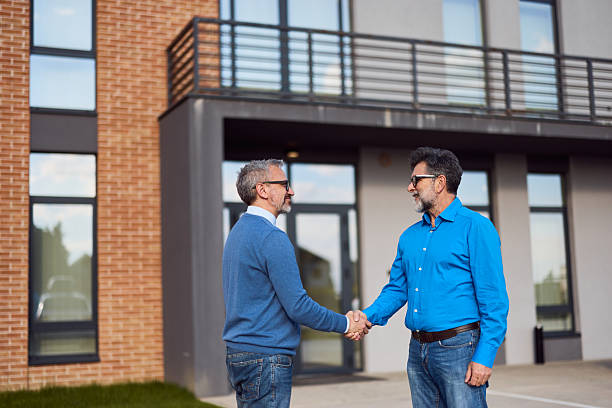 istock Businessmen Shaking Hands Outdoors Near a Modern Building 2218645686