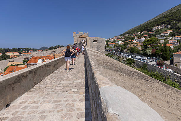 Walking route around Old Walls, a steep road leading to medieval fortified tower Minceta, Dubrovnik, Croatia Dubrovnik, Croatia - June 27, 2023: Walking route around Old Walls, a steep road leading to medieval fortified tower Minceta. Old Town with historical center is known as pearl of Dalmatia fort minceta dubrovnik stock pictures, royalty-free photos & images