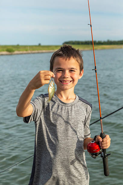 istock Boy Holding Small Fish He Caught While Fishing 2218646581