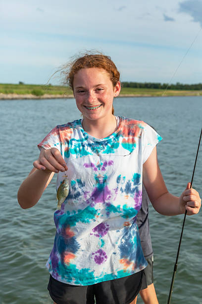 istock Girl Holding Small Fish She Caught While Fishing 2218646596