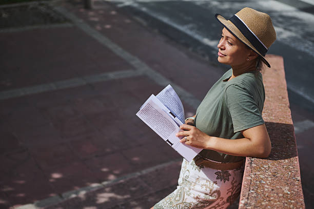 istock Woman Relaxing Outdoors on a Bright Day While Reading a Magazine 2218646745