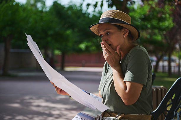 istock Woman Outdoors Reacting to Letter, Displaying Shock and Concern in Natural Light 2218647587