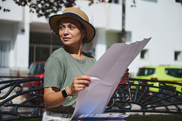 istock Woman Sitting Outdoors Reading Large-Format Material in Daylight 2218647590