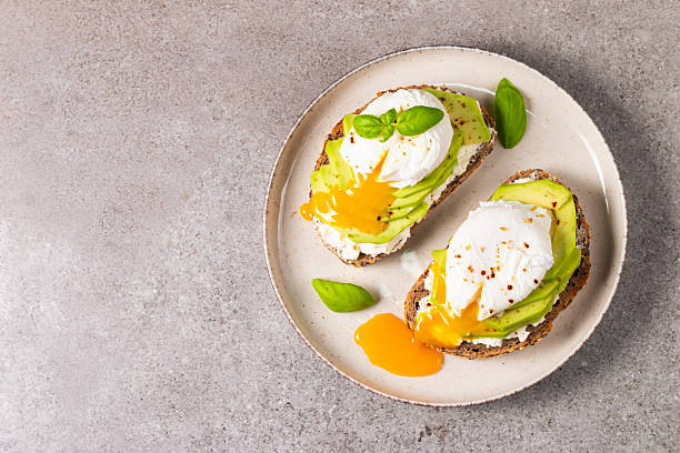 istock Toast with avocado, soft cream cheese, rye bread and poached Egg. Wholemeal open sandwich for healthy breakfast concept 2218651898