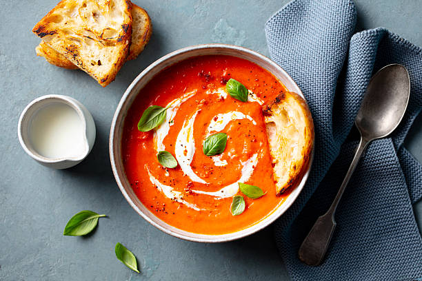 istock Tomato soup with cream in a white bowl on grey background. Close up. Top view. 2218652709