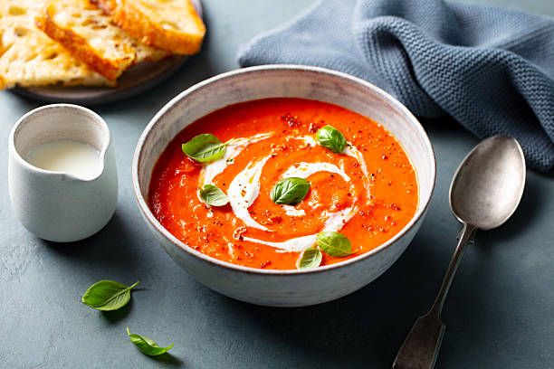 istock Tomato soup with cream in a white bowl on grey background. Close up. 2218653239