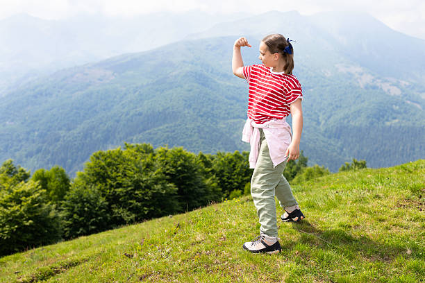 It's early summer in the high mountain pastures surrounding Bielmonte in the Zegna Oasis. The sun is shining and nature is awakening from its winter hibernation. Here is a cute little girl working out in front of the wild inhabited valley, called Valsessera, stretching between the Cervo Valley and Valsesia. Proud of her fitness, she engages in some gymnastic exercises. The majestic alpine scenery gives her a kind of inner strength, confronting her potential as a growing girl with almighty nature.