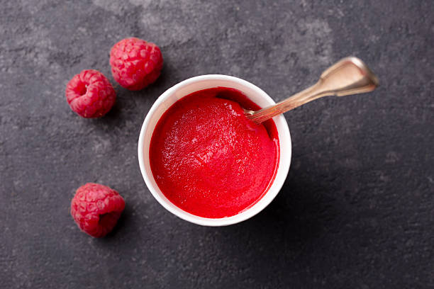 istock Raspberry sorbet in paper cup. Black stone background. Close up. Top view. 2218653535