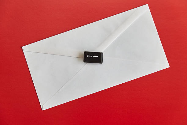 istock A white envelope and the Enter key from a computer keyboard on it against a bright red background, mailing, email, old and modern technologies. 2218654336