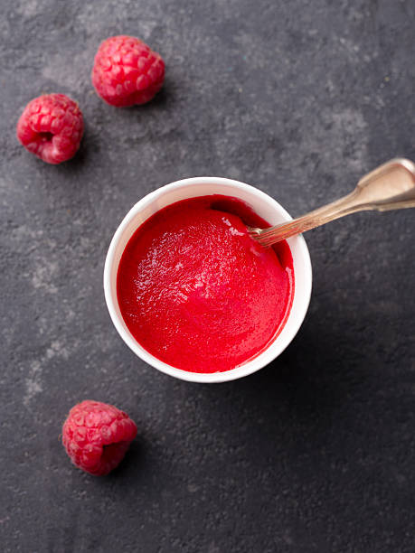 istock Raspberry sorbet in paper cup. Black stone background. Top view. 2218654571