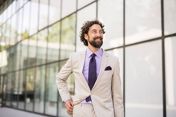 istock Smiling businessman walking outside office building looking up 2218655623