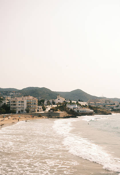 Gentle waves washing ashore on a sunny beach in santa ponsa, mallorca, with tourists enjoying their summer vacation