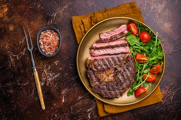 istock Dinner with Grilled Rib eye steak, fried dry aged beef meat. brown background. top view 2218660839