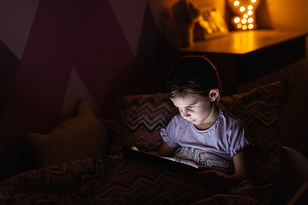 istock Young Girl Using a Tablet in Bed During the Evening 2218660935