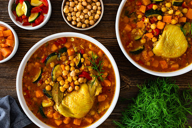 istock Fresh vegetable soup with lentil, chickpea and chicken on wooden table 2218661235