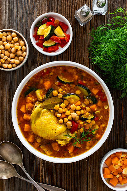 istock Fresh vegetable soup with lentil, chickpea and chicken on wooden table 2218661246