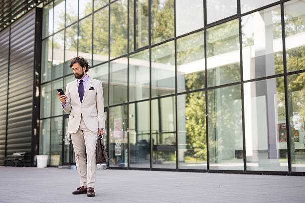 istock Businessman using smartphone outside modern office building 2218663682