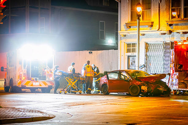 Milwaukee, WI, USA - 04-30-2025: Emergency medics perform CPR on an injured person following a heavy car crash on a city street at night